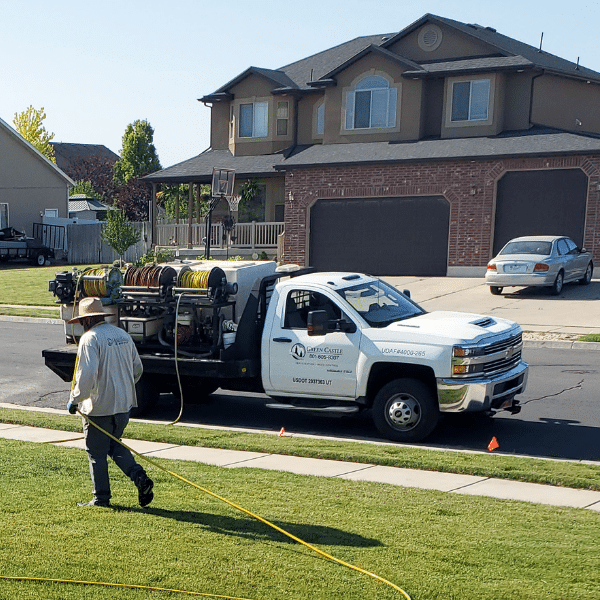 Lawn Seeding Services You Can Trust In Ogden, Utah Professional applying fertilizer and aerating lawn in Northern Utah backyard
