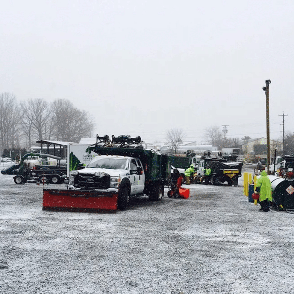 Facility manager inspecting freshly plowed industrial parking lot in winter